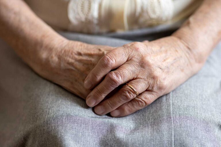 Family member reviewing a care plan with an older adult at a table in an assisted living residence.
